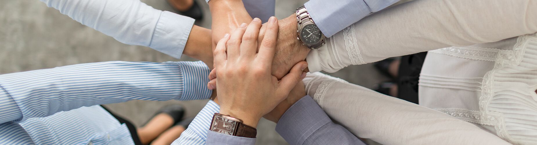 Mehrere Personen legen die Hände aufeinander
