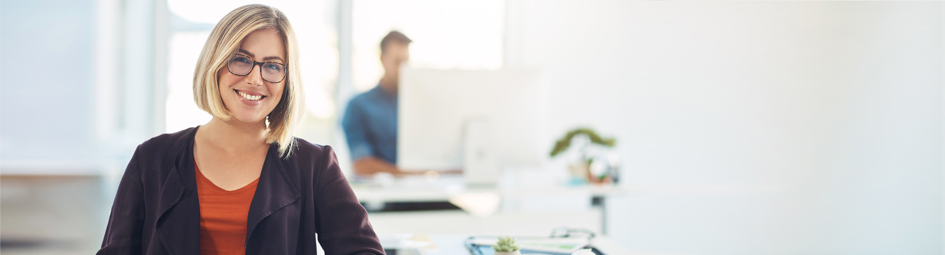Frau sitzt im Büro und lächelt